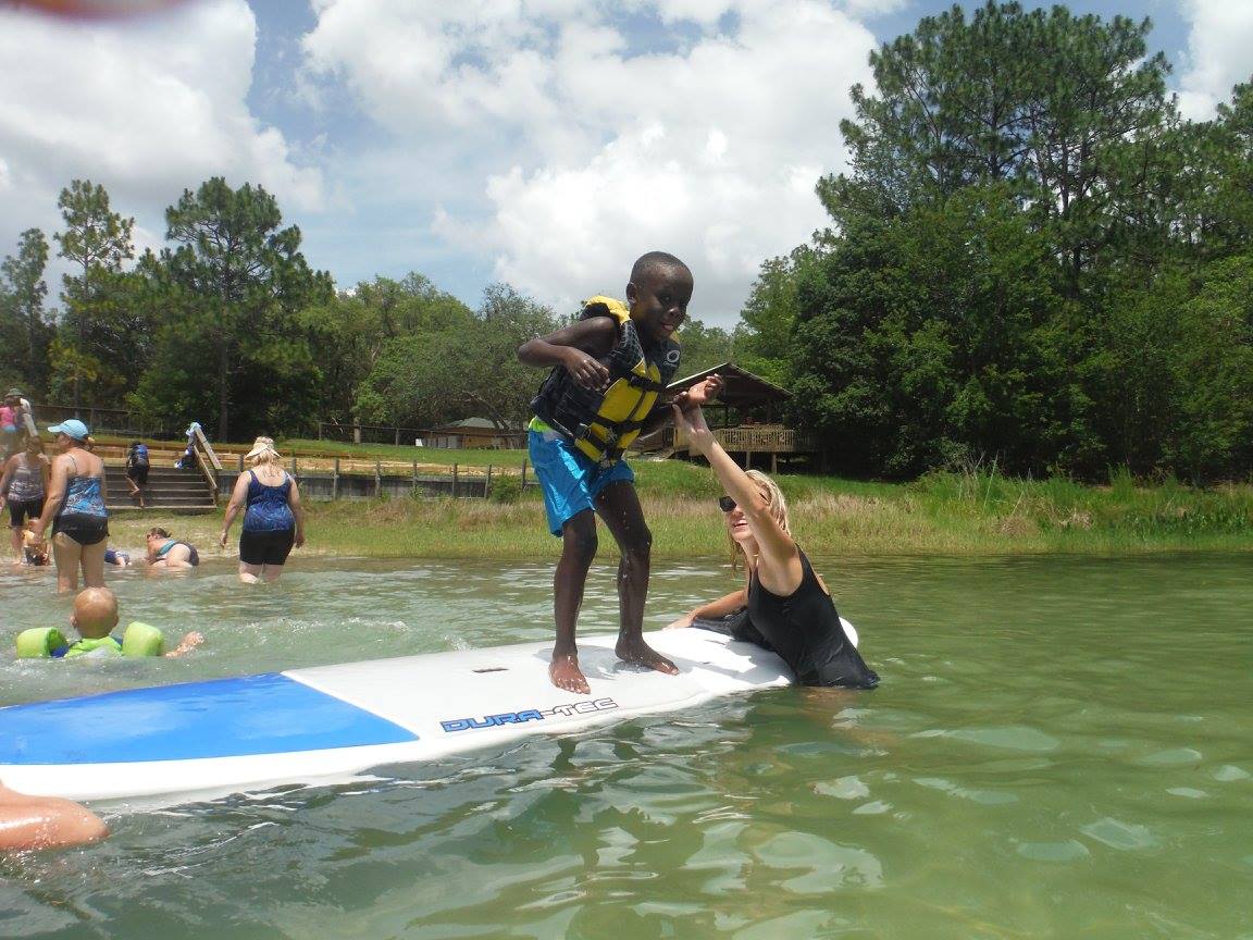 blind child learning to paddle board