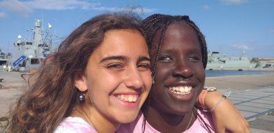 Two girls smiling in the photo both wearing pink shirts.