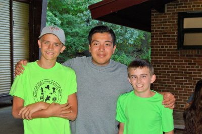 Sean and two camp abilities peers posing for a photo with their arms around each other. All 3 are smiling at the camera. 