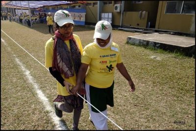 A coach assisting an athlete walk with the guide wire.