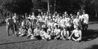 A group photo of athletes and coaches smiling for a photo.
