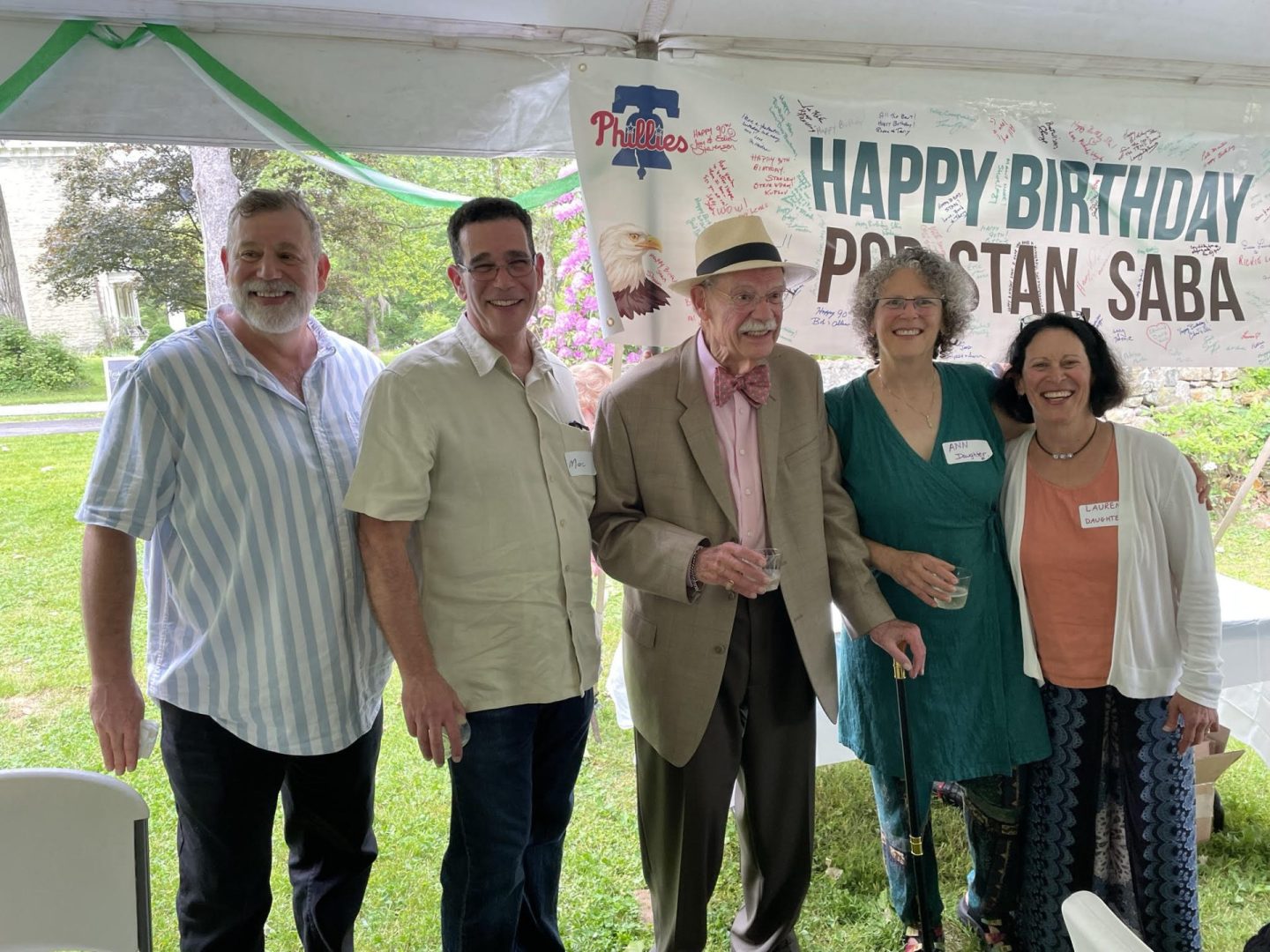 Dr. Lauren Lieberman with her sister, dad, and two brothers standing in front of a happy birthday pop Stan banner, smiling at the camera with arms around each other.